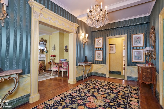 foyer entrance with crown molding, parquet flooring, and a chandelier