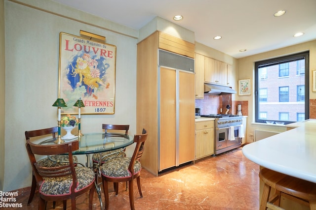 kitchen featuring backsplash, light brown cabinetry, and premium appliances