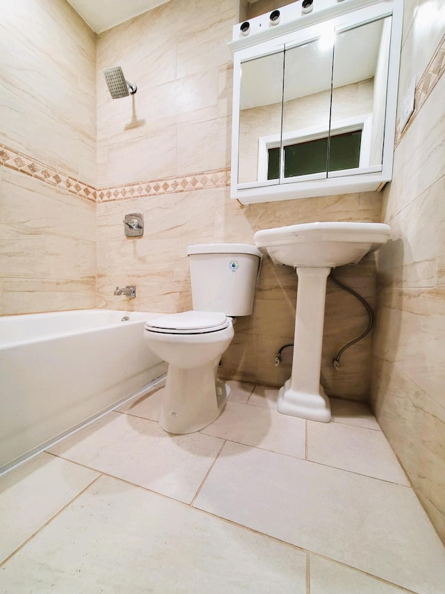 full bathroom featuring tile patterned floors, tile walls, toilet, and shower / washtub combination