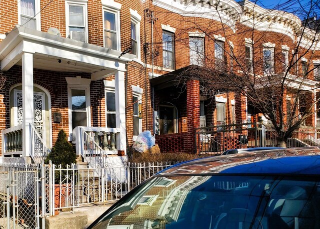 view of front facade with fence and brick siding