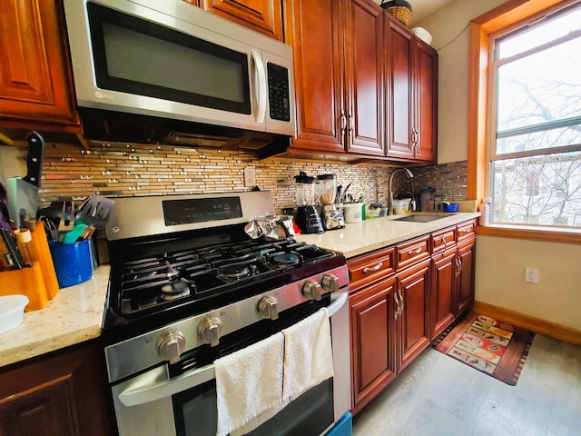 kitchen with a sink, tasteful backsplash, stainless steel appliances, and a wealth of natural light