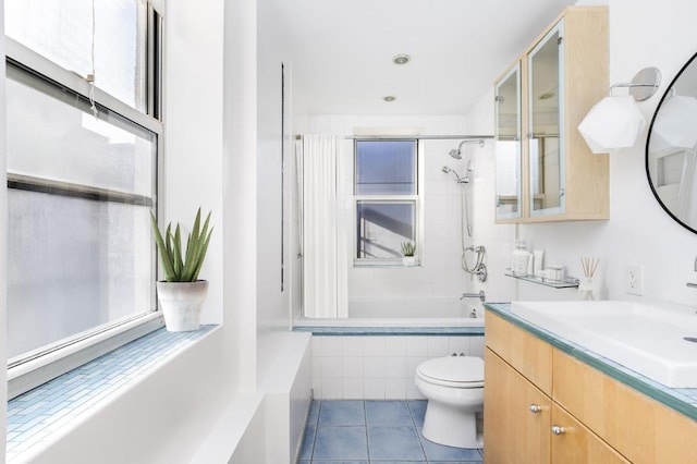 bathroom with tile patterned flooring, tiled shower / bath combo, vanity, and toilet