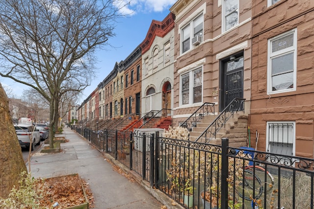 view of building exterior with a residential view and a fenced front yard