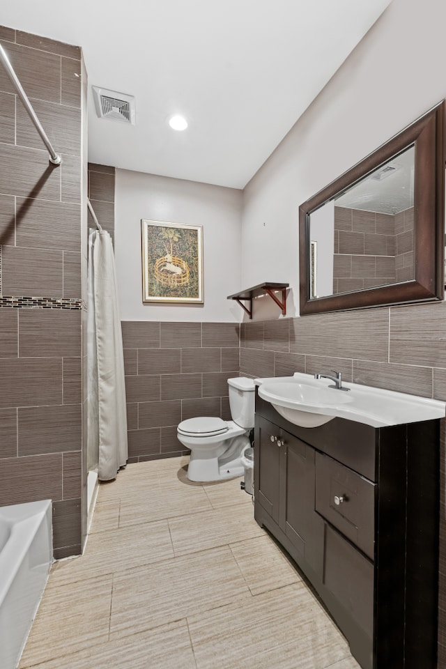 full bathroom featuring visible vents, toilet, curtained shower, tile walls, and vanity