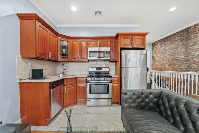 kitchen with light tile patterned flooring, sink, crown molding, stainless steel appliances, and decorative backsplash