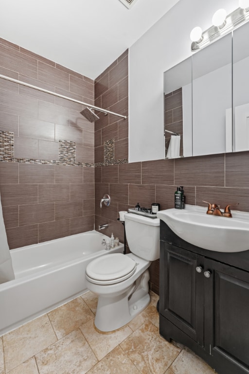 full bathroom featuring shower / tub combo with curtain, toilet, tasteful backsplash, tile walls, and vanity