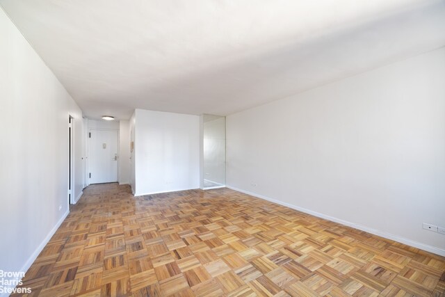 empty room featuring light parquet flooring and radiator heating unit