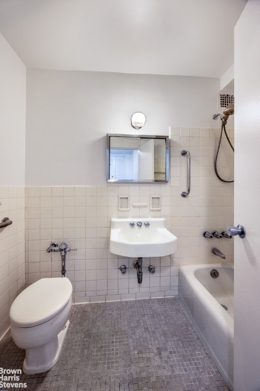 full bathroom with sink, tile walls, tile patterned floors, and toilet