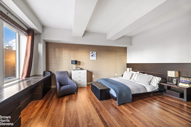 bedroom featuring beamed ceiling and wood finished floors