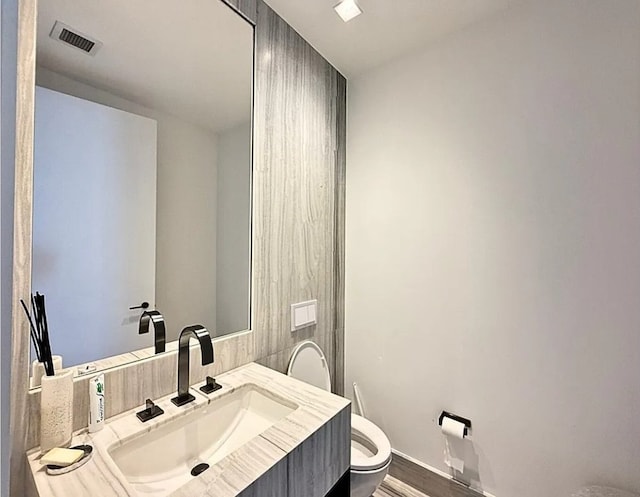 bathroom featuring vanity, hardwood / wood-style floors, and toilet