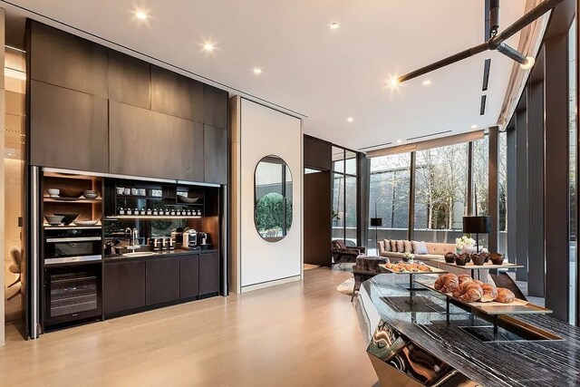 bar with floor to ceiling windows and light wood-type flooring