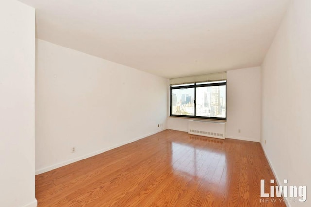 spare room with radiator and light hardwood / wood-style floors