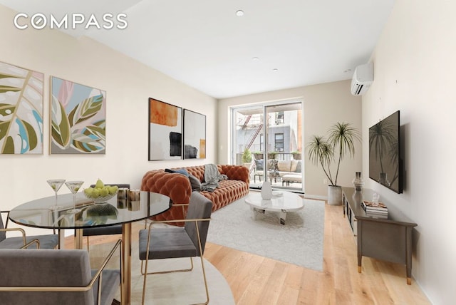 living room featuring a wall mounted air conditioner and light hardwood / wood-style floors