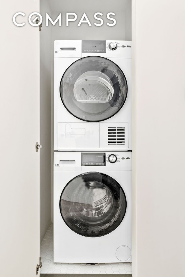 laundry area featuring stacked washer / drying machine and laundry area