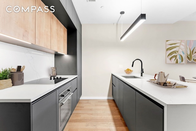 kitchen with a peninsula, modern cabinets, black electric cooktop, and oven