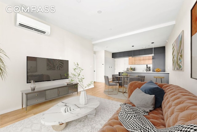 living room with a wall unit AC and light hardwood / wood-style floors