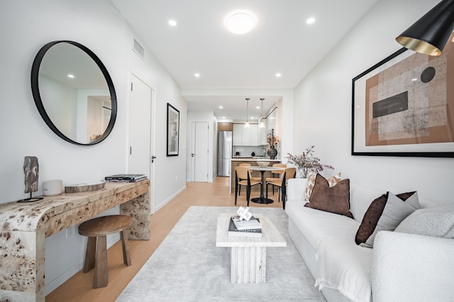 living room featuring light wood finished floors, recessed lighting, and baseboards