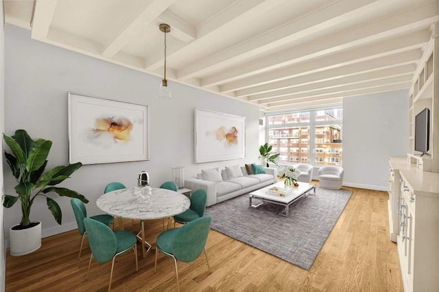 living area featuring light wood-style floors, beam ceiling, and baseboards