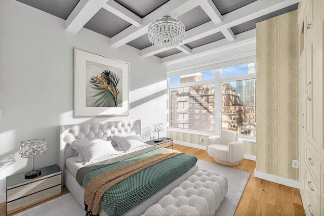 bedroom with an inviting chandelier, light wood-type flooring, coffered ceiling, beamed ceiling, and baseboards