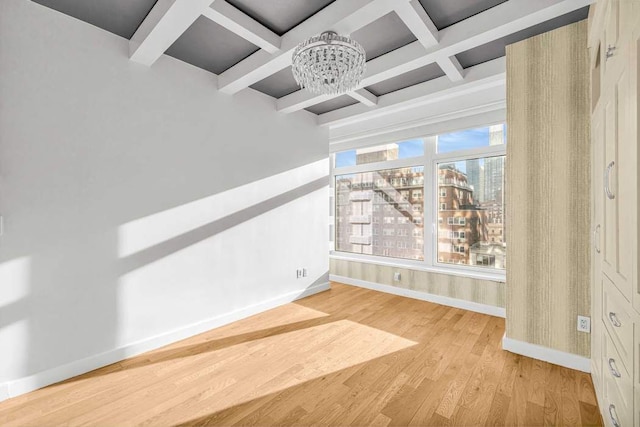 interior space with light wood-style floors, baseboards, coffered ceiling, and beam ceiling