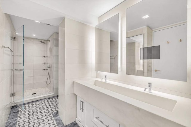 full bathroom featuring double vanity and a stall shower