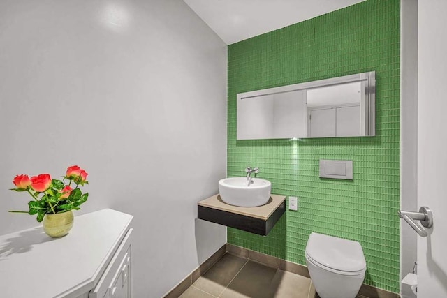 bathroom featuring tile patterned flooring, a sink, toilet, and baseboards