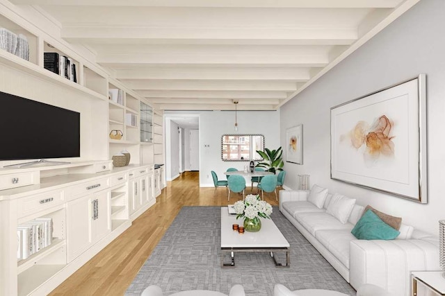 living room featuring baseboards, beamed ceiling, and light wood-style floors