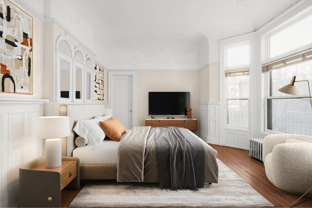 bedroom featuring radiator heating unit and wood finished floors