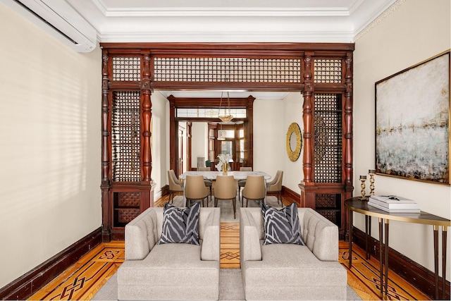 sitting room featuring wood finished floors, crown molding, baseboards, and a wall mounted AC