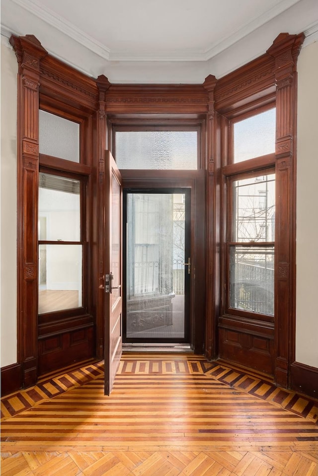 foyer entrance featuring crown molding and baseboards