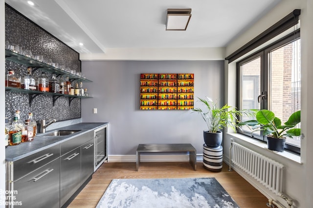 bar with sink, wine cooler, radiator, and light hardwood / wood-style floors