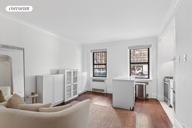 living room featuring dark hardwood / wood-style flooring, radiator heating unit, and ornamental molding