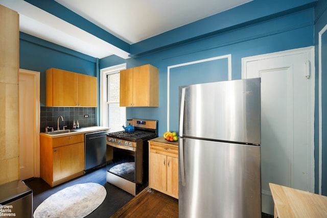 kitchen featuring stainless steel appliances, a sink, and decorative backsplash