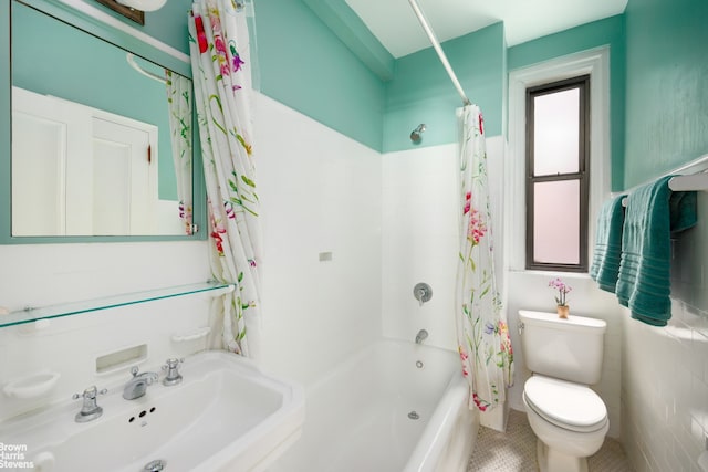 bathroom with toilet, shower / bath combo, and a sink