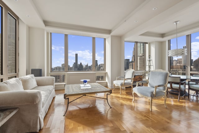 living room featuring light parquet floors, plenty of natural light, and a tray ceiling