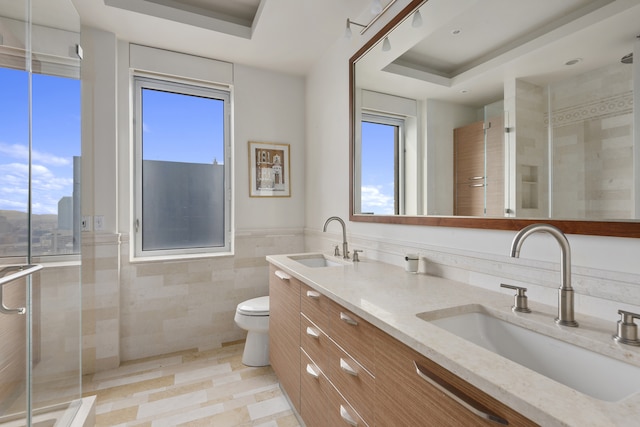 bathroom with a shower stall, tile walls, and a sink