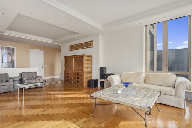 living area with baseboards and a tray ceiling
