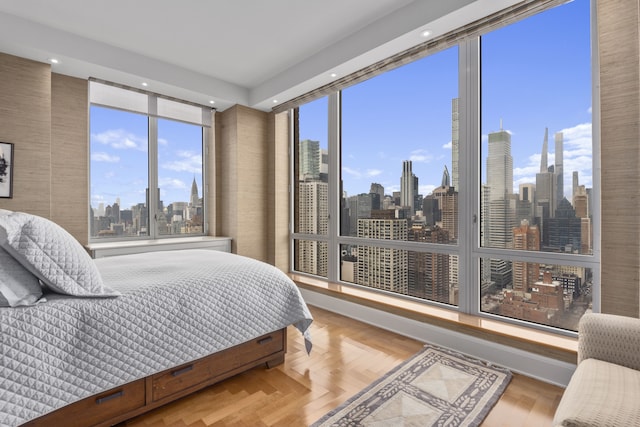 bedroom featuring a city view and wood finished floors