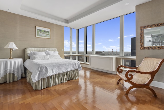 bedroom featuring a tray ceiling and wallpapered walls