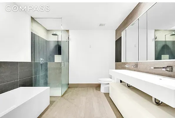 full bathroom featuring a shower stall, a freestanding tub, and toilet