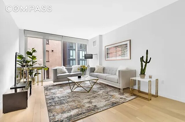 540 W 49th St Unit 406N, New York City, NY 10019 - living room with wood finished floors, floor to ceiling windows, and baseboards