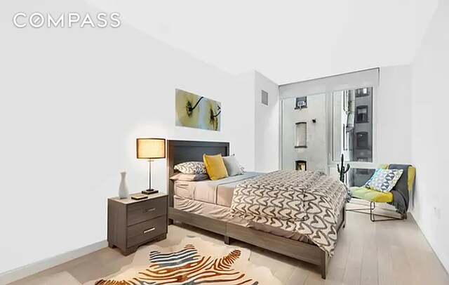540 W 49th St Unit 406N, New York City, NY 10019 - bedroom featuring light wood-style floors and baseboards