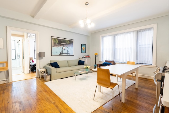 living room with hardwood / wood-style flooring, baseboards, a notable chandelier, and beam ceiling
