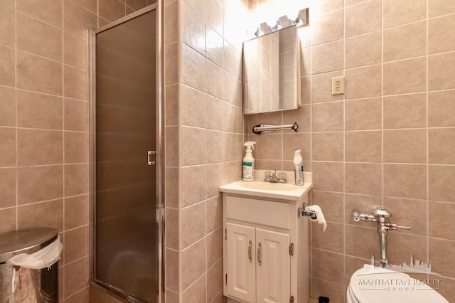 full bathroom with toilet, a stall shower, vanity, and tile walls