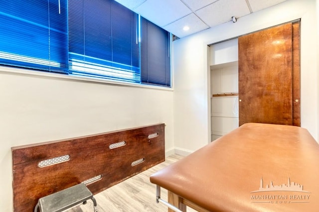 interior space featuring a drop ceiling and hardwood / wood-style flooring