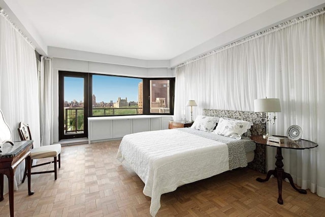 bedroom featuring parquet floors and access to exterior