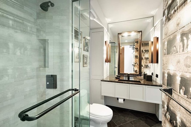 bathroom with toilet, a stall shower, and vanity