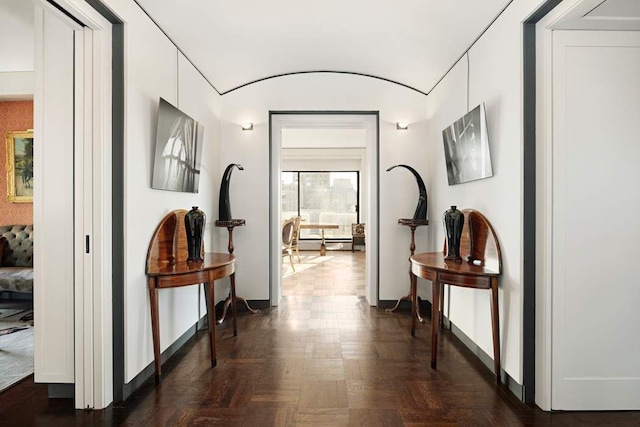 hallway with dark parquet floors and a baseboard heating unit