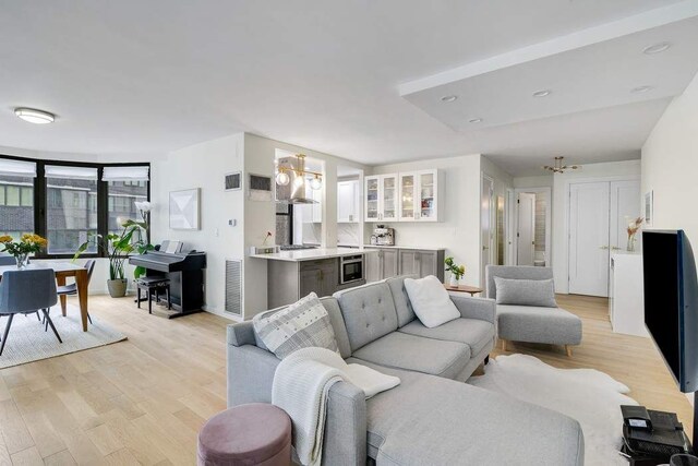 living room with a notable chandelier and light hardwood / wood-style floors