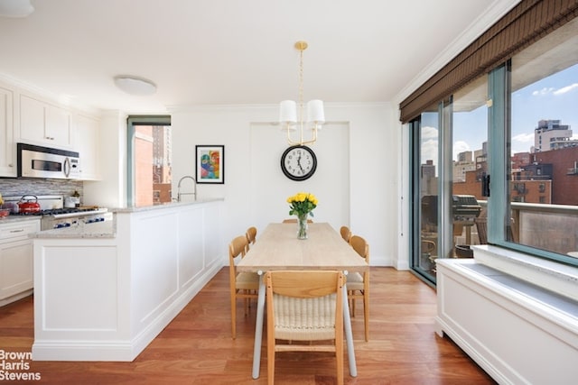 dining room with crown molding, plenty of natural light, and wood-type flooring